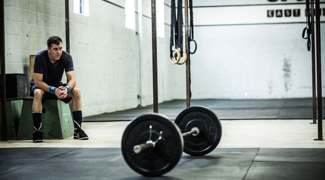 Man Tired, Resting In The Gym With Barbell Man Tired, Resting In The Gym With Barbell