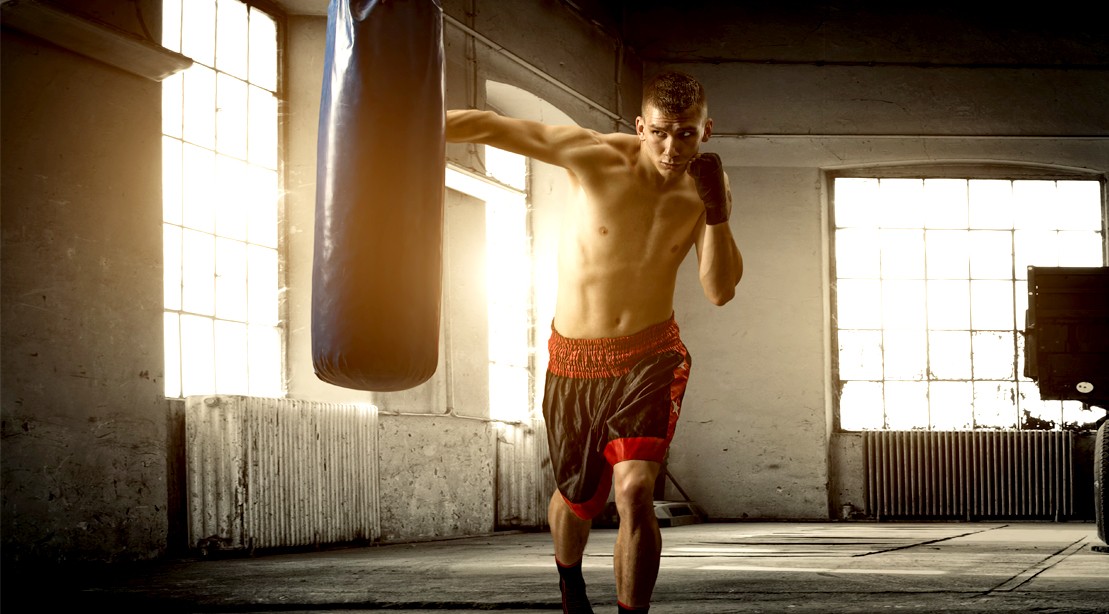 Young-Boxer-Punching-Heavy-Bag-In-Boxing-Gym Young-Boxer-Punching-Heavy-Bag-In-Boxing-Gym